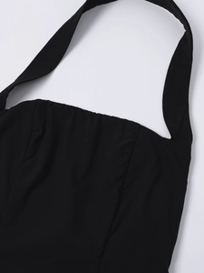 Détail du décolleté dos nu noir montrant le tissu plissé délicat et les coutures fines