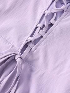 Close-up detail of the cross strap lace-up design on this light purple fishbone dress