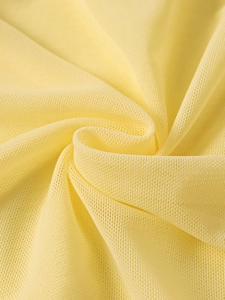 Détail de près du tissu en maille jaune clair respirant avec texture plissée élégante