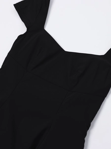 Close-up of the square neckline and smooth fabric texture of this black mini dress