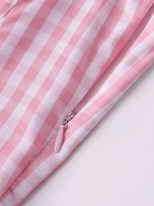 Detailed macro view of the invisible zipper on pink and white plaid fishbone dress