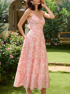 Détail du grand nœud papillon au dos et des volants sur une robe longue à fleurs roses