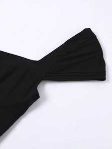Close-up of black knitted dress showing shoulder detail and tiered ruffled sleeve texture