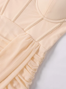 Détail du tissu en maille froncée et de la structure à baleines sur une robe bustier champagne