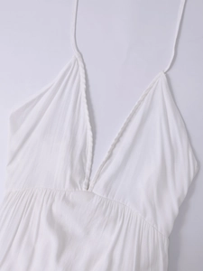 Detail of white V-neck dress with gathered high waist and textured breathable fabric