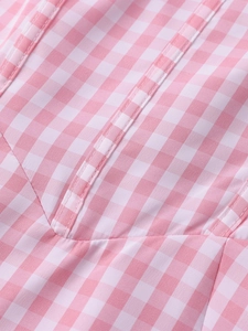 Detailed close-up of pink and white gingham fabric with structured stitching on the waist