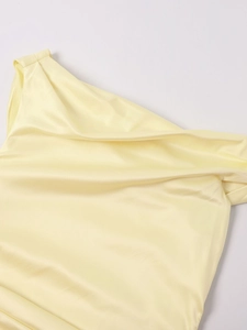 Detail of light yellow satin dress showing the smooth fabric texture and shoulder draping