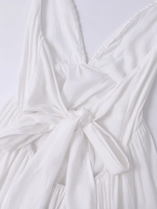 Detail of white deep V-back dress with large bow-knot and delicate lace embroidery