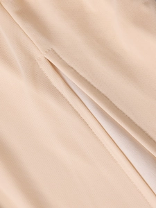 Gros plan détaillé du tissu en maille beige clair avec broderie fine et couture de robe