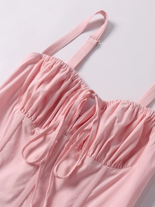 Detail of pink corset dress with adjustable straps and cross-lace chest design