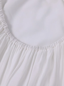 Detailed close-up of elastic ruffled edges on a white deep V-neck halter maxi dress