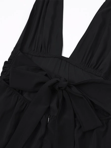 Detail der Rückenschleife, des Neckholder-Designs und des Reißverschlusses am schwarzen Kleid
