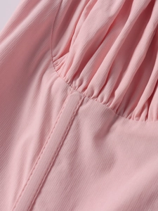 Detailed view of pink pleated fabric and fine vertical texture on the A-line dress