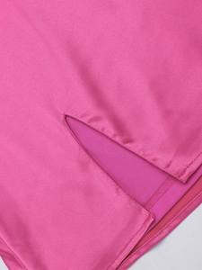 Dettaglio dell'abito in raso rosa con design a spacco, cuciture pulite e trama del tessuto