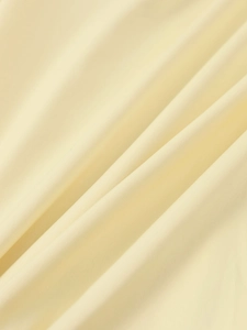 Detail of premium pale yellow satin fabric texture with elegant pleated draping