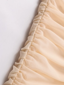 Détail du tissu en maille champagne avec plissage délicat et texture de filet fin