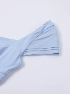 Detailed view of square neck pleated fabric and fine stitching on the blue A-line dress