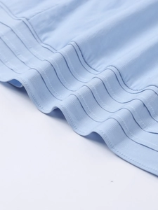 Detailed macro view of light blue dress fabric with parallel stitching and pleat textures