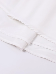 Detailed close-up showing precise single-needle stitching on the white dress hemline