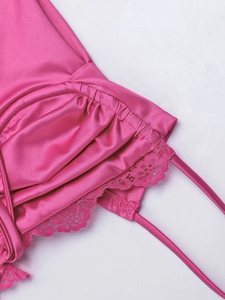 Dettaglio di un abito in raso rosa con pizzo delicato e sottili spalline a spaghetti