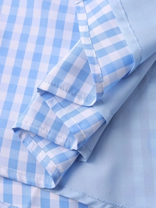 Detailed close-up of blue and white gingham fabric with neat stitching on hemline