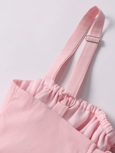 Detail of adjustable thin straps with metal rings on pink bodycon dress