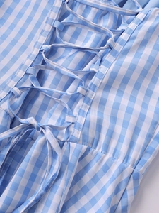 Detailed view of the blue gingham dress featuring a lace-up back design and woven texture