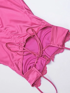 Dettaglio macro dell'abito in raso rosso rosa con pizzo e lacci regolabili sul retro