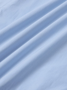Close-up of light blue fabric texture showing high-quality fine plain weave and soft folds