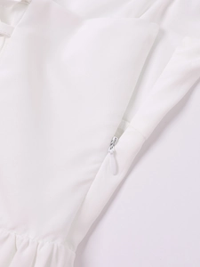 Detail of white stretch dress featuring a hidden zipper and subtle pleated fabric texture