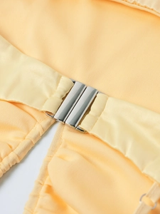 Detail der silbernen Metallschnalle an einem eleganten hellgelben Satin-Unterkleid