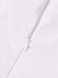 Détail de la fermeture éclair invisible et du tissu en tencel blanc sur la robe
