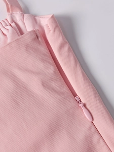 Detail of pink corset dress showing high-quality invisible zipper and ribbed fabric texture
