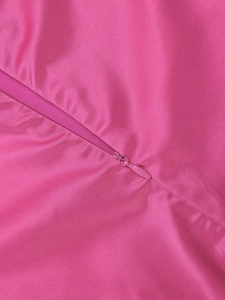 Dettaglio della cerniera invisibile su abito in raso rosso rosa con cuciture di qualità
