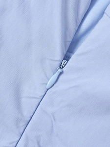 Detail of light blue dress showing invisible zipper and textured fabric weave
