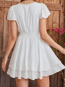 Detail of white dress back showing ruffled layered hem and hidden zipper closure