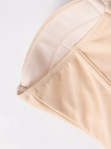 Gros plan détaillé montrant les coutures renforcées et le bustier d'une robe beige