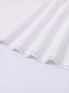 Détail d'une robe blanche en Tencel montrant la texture plissée et l'ourlet fini