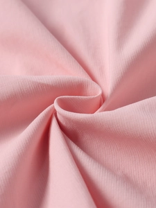 Close-up of light pink ribbed fabric texture with soft folds on a bodycon mini dress