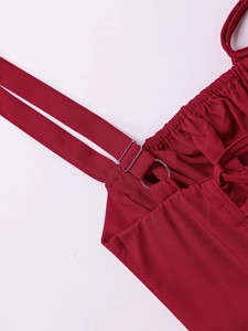 Detail of wine red dress featuring adjustable spaghetti straps and shirred neckline trim