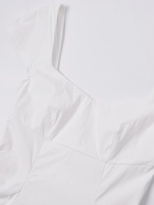 Detailed macro view of the sweetheart neckline and textured woven fabric on a white dress