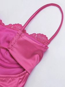 Dettaglio dell'abito in raso rosso rosa con pizzo e cuciture fini su tessuto di alta qualità