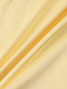 Makro-Detail von hochwertigem hellgelbem Satinstoff mit glatter Textur und Fall