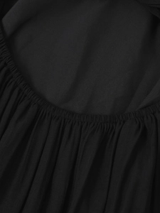 Close-up of elastic pleated waist detail on a black halter neck backless maxi dress