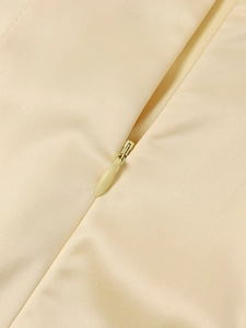 Close-up of high-quality invisible zipper on a cream satin V-neck dress detail