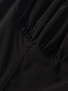 Detail of black fabric texture showing subtle pleats and fine sewing craftsmanship