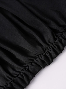 Detailed close-up of elastic ruching technique on a black mesh bodycon dress fabric