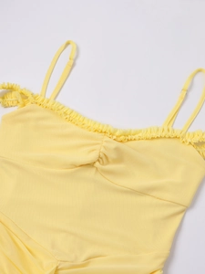 Detail of light yellow mesh dress with delicate ruffled edges and adjustable thin straps