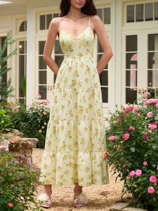 Détails d'une robe longue fleurie jaune avec col en V, fines bretelles et jupe à volants