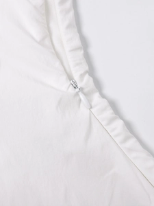 Close-up of white dress showing hidden back zipper and vertical fabric texture